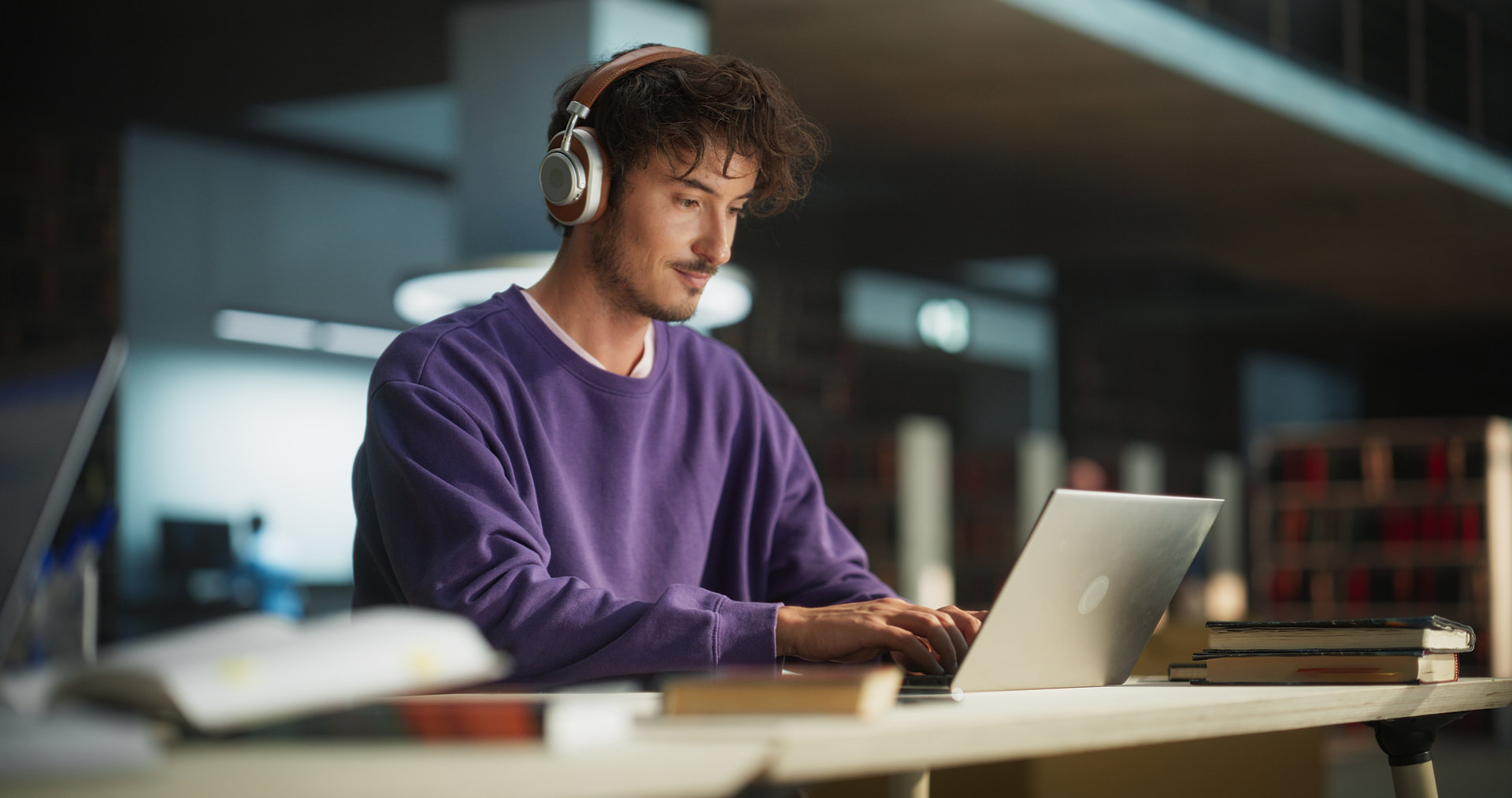 Person wearing headphones working on a laptop computer